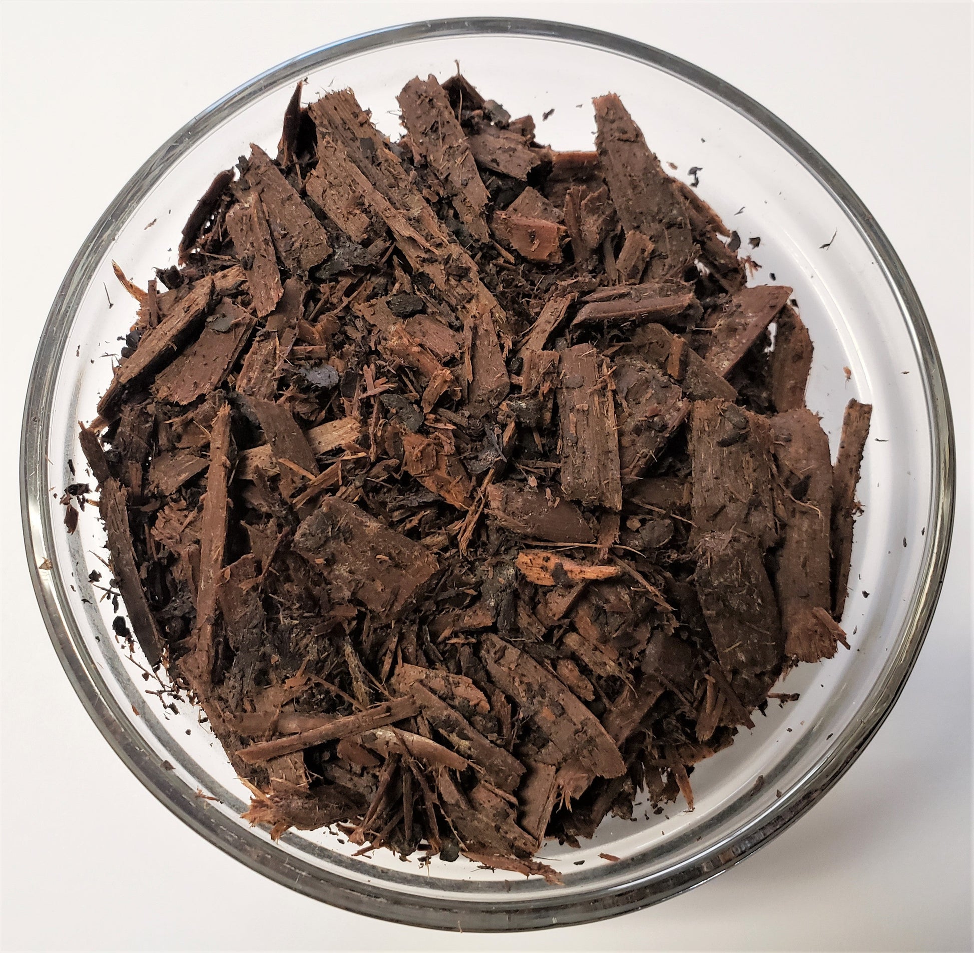 Close-up of The Soil Makers Witch Hazel Mulch made from the byproduct of witch hazel distillation. Lightweight organic wood chips that help retain soil moisture, support healthy soil, and provide a natural mulch layer for raised beds, gardens, and container plants.