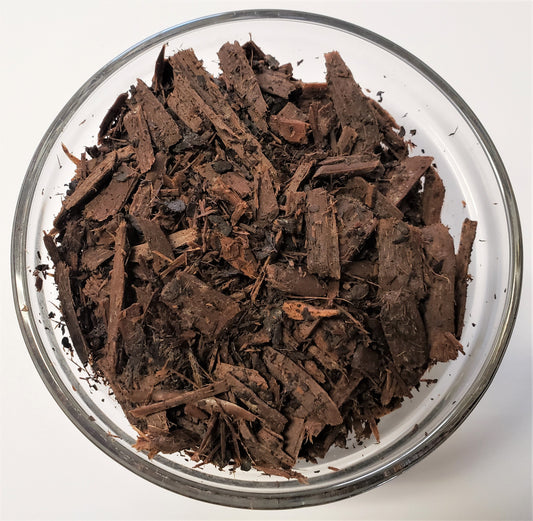 Close-up of The Soil Makers Witch Hazel Mulch made from the byproduct of witch hazel distillation. Lightweight organic wood chips that help retain soil moisture, support healthy soil, and provide a natural mulch layer for raised beds, gardens, and container plants.